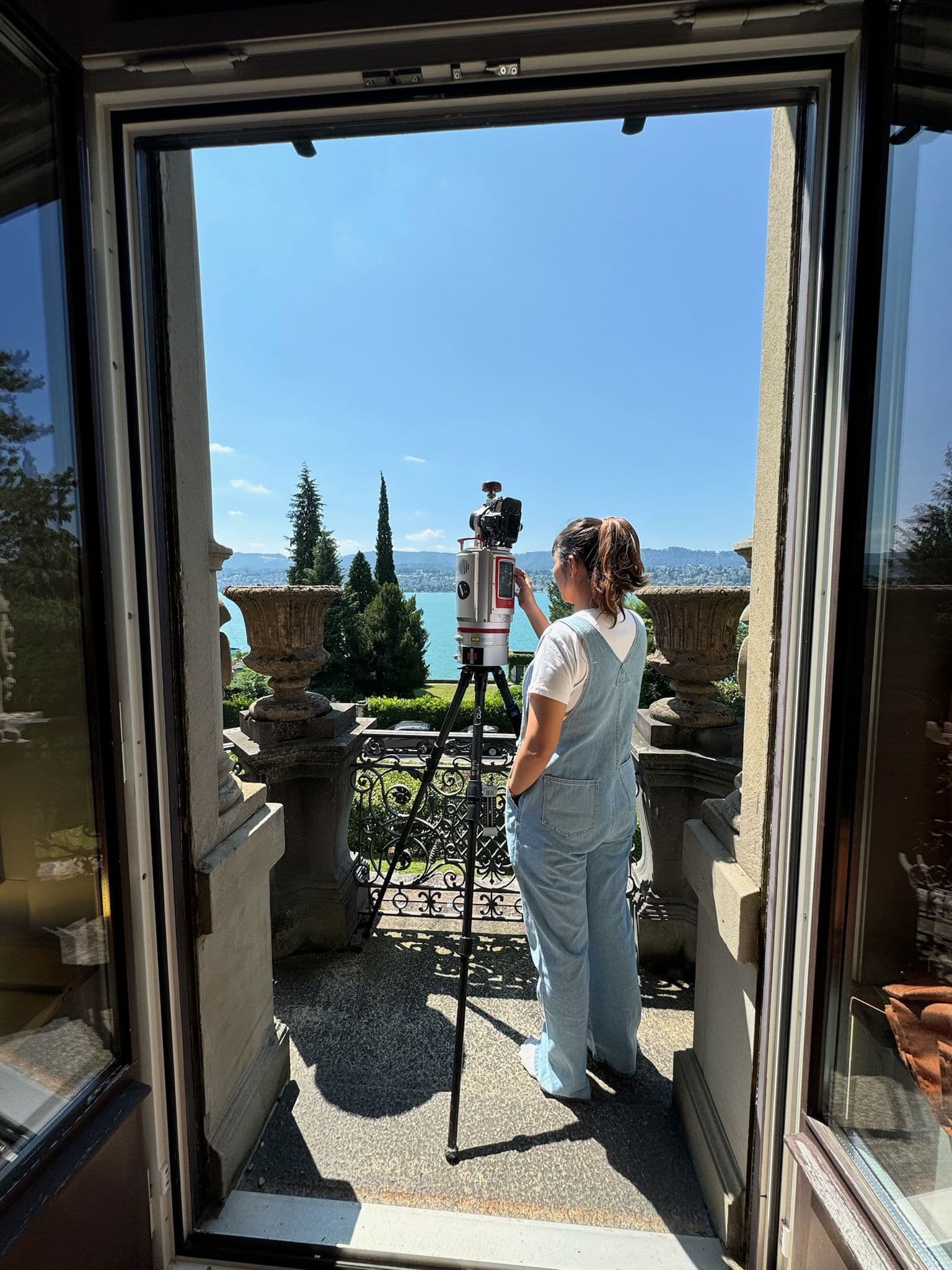 Frau verwendet Kamera auf Terrasse mit Seeblick.