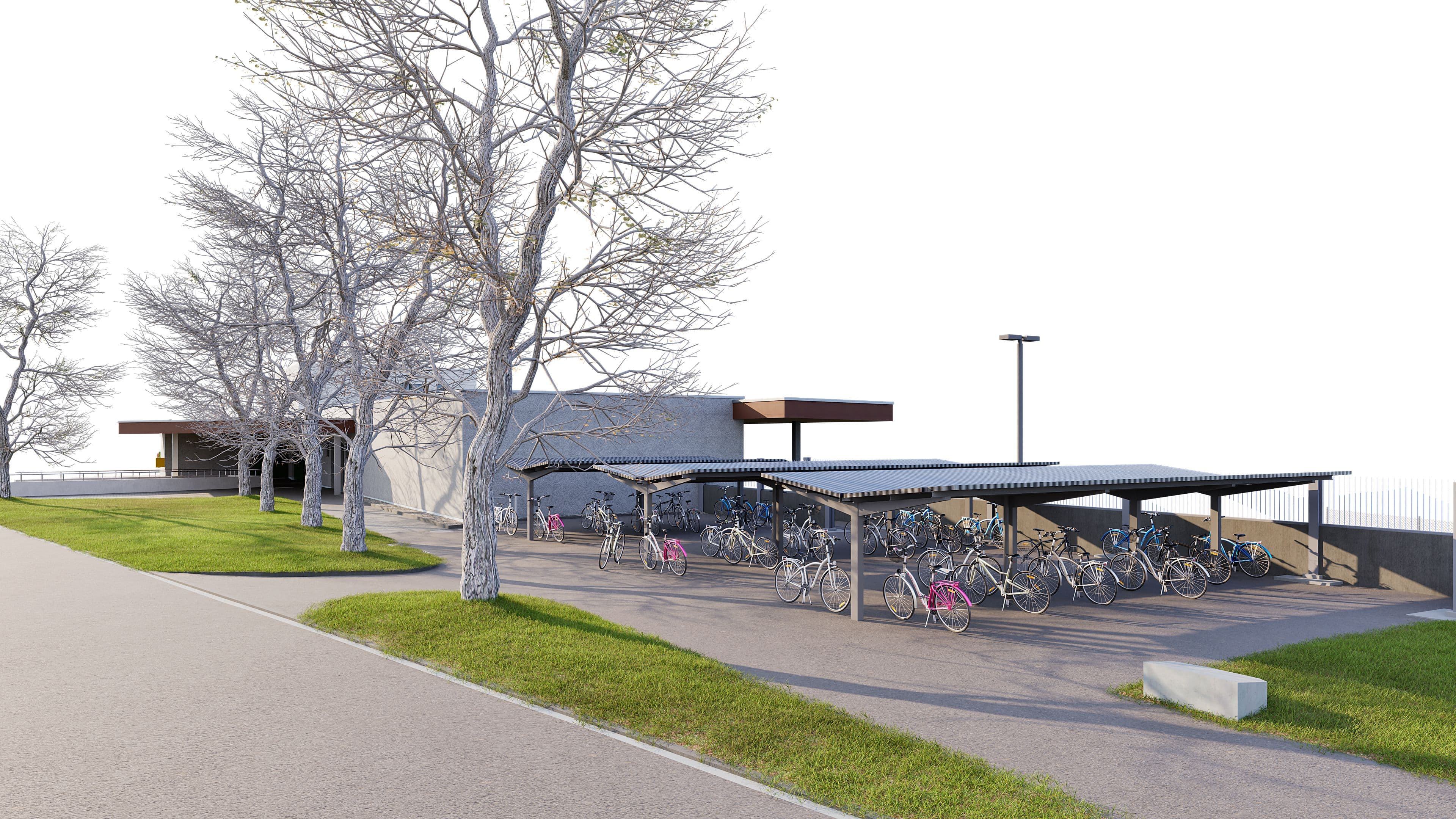 Ein moderner Gebäudekomplex mit überdachtem Fahrradstellplatz und kahlen Bäumen im Vordergrund.