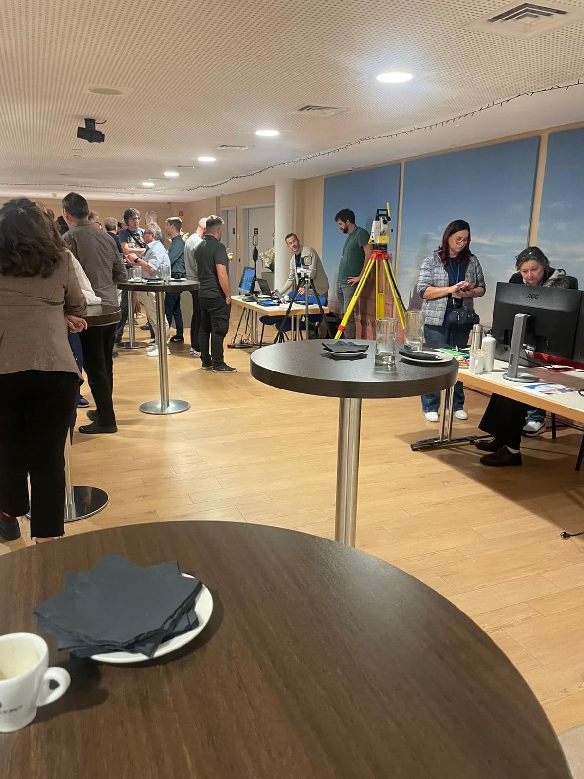 Eine Gruppe von Menschen versammelt sich in einem modernen Büro mit Computern und technischen Geräten.