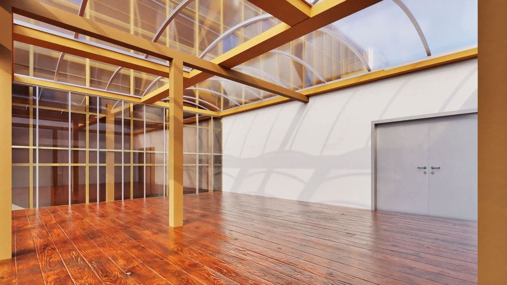 Heller Innenraum mit Holzfußboden, großen Glaswänden und transparentem Tonnengewölbe-Dach; sichtbare Holzbalken und graue Doppeltür an weißer Wand.