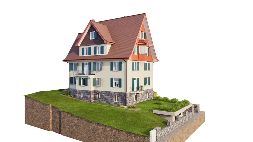 Freistehendes Einfamilienhaus mit rotem Dach, Putzfassade und Dachgauben auf angehobenem Gelände.