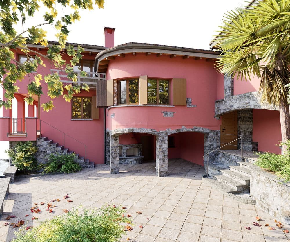 Rosa Villa mit moderner Architektur, umgeben von Bäumen und offenem Innenhof.