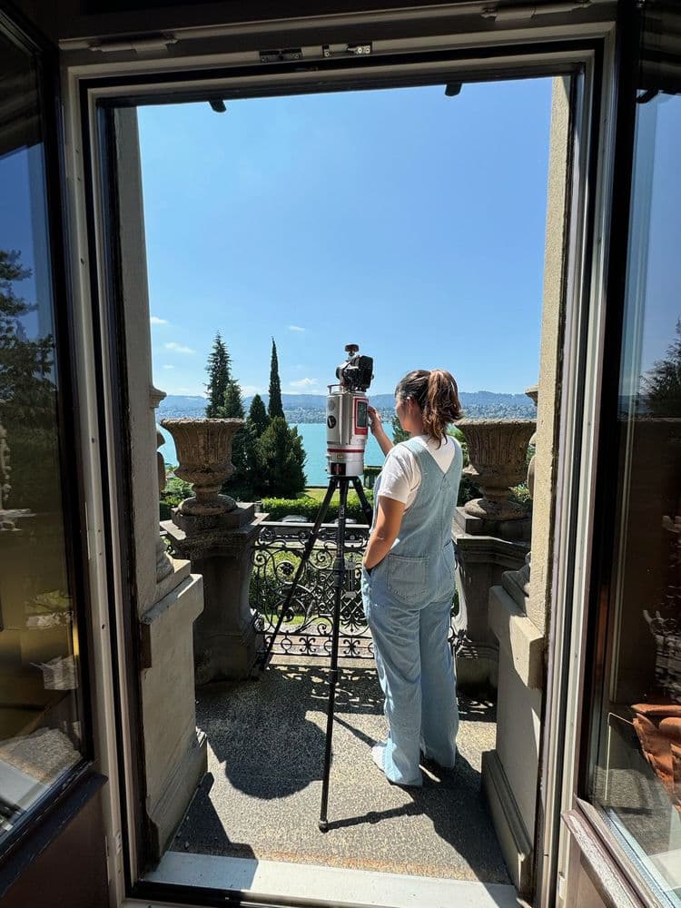 Frau verwendet Kamera auf Terrasse mit Seeblick.