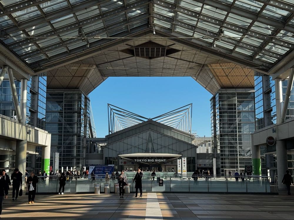 Tokyo Big Sight, modernes Kongresszentrum mit auffälliger Architektur und Glasfassaden, Menschen laufen in der Haupthalle.