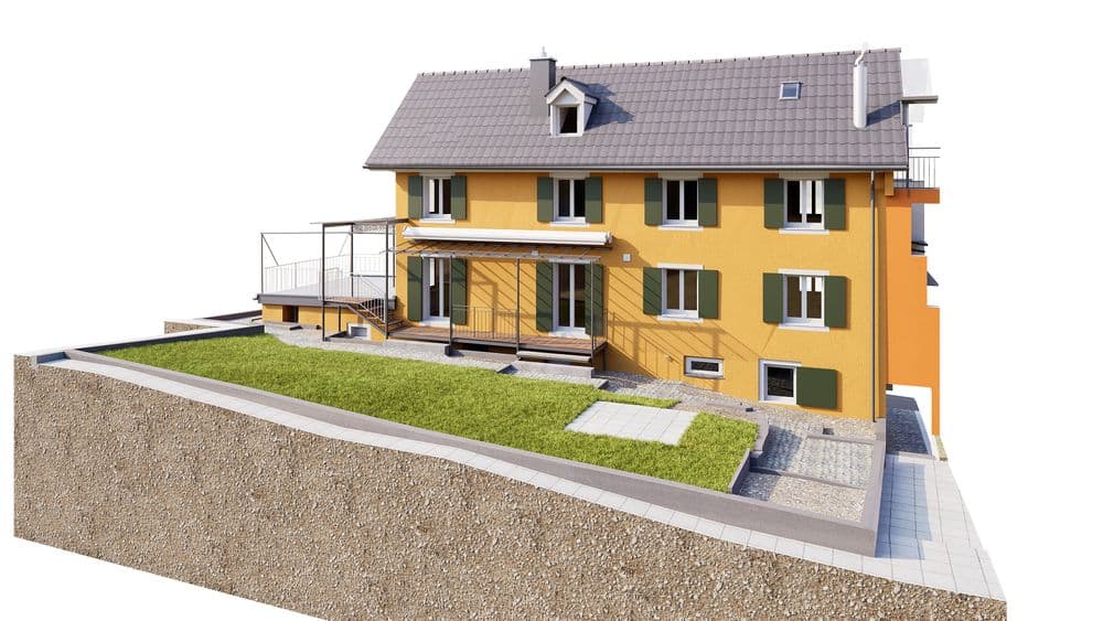 3D-Visualisierung eines gelben Mehrfamilienhauses mit grauem Satteldach, Balkonen und Garten auf Hanggrundstück, mit Treppen und Zufahrt vor weißem Hintergrund.