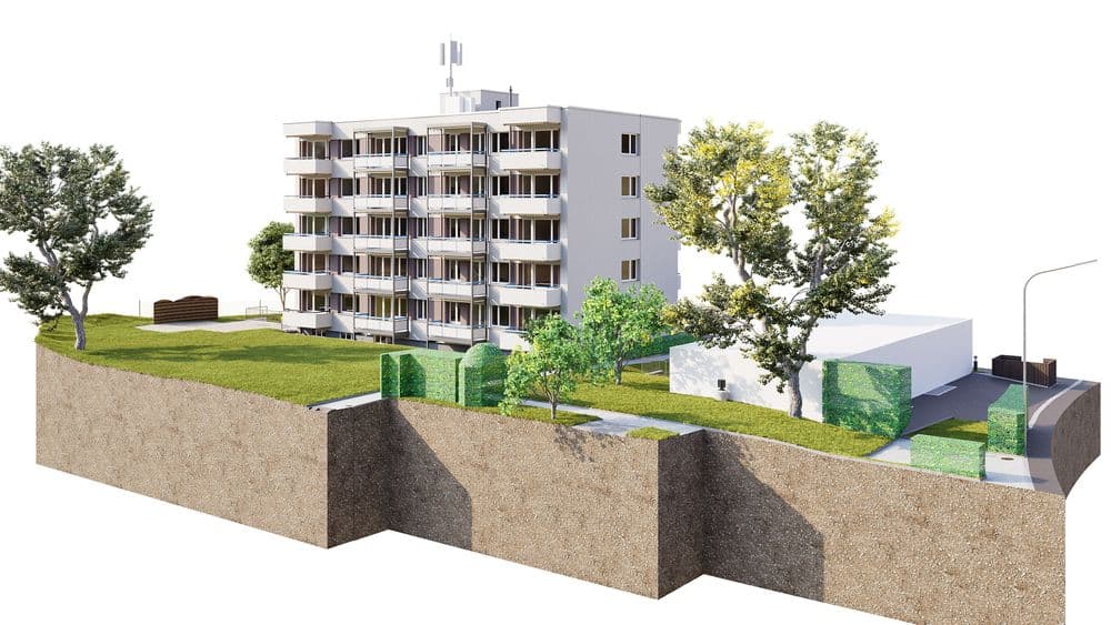 3D-Architekturvisualisierung eines mehrstöckigen Wohnhauses mit Balkonen auf erhöhtem Gelände, Grünflächen, Bäumen, Hecken und angrenzender Straße; Schnittdarstellung des Bodens und der Umgebung.