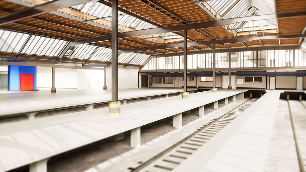 Leere Industriehalle mit Förderbändern und Oberlichtern.