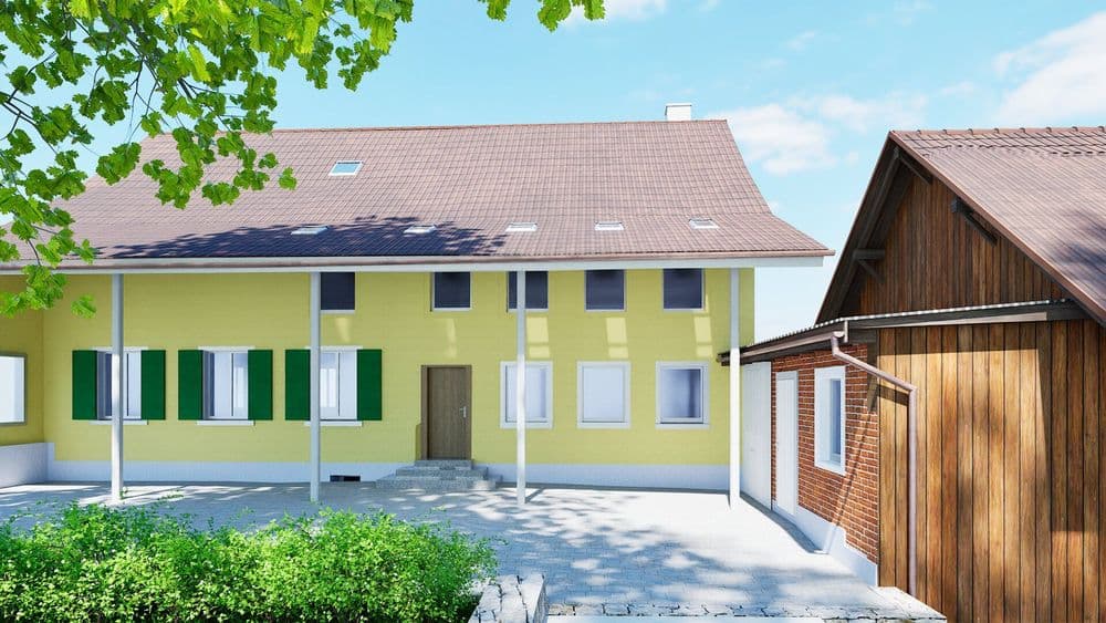 Gelbes Wohnhaus mit grünen Fensterläden und Nebengebäude unter blauem Himmel.