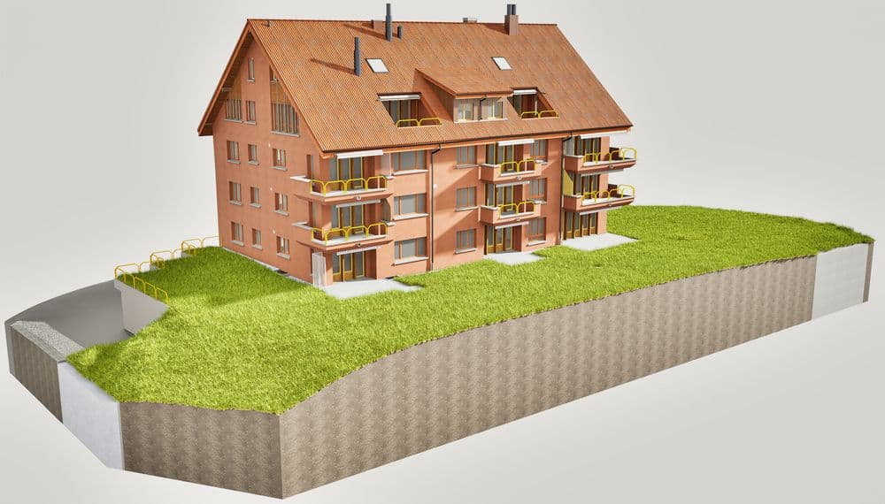 Mehrfamilienhaus mit Satteldach und Balkonen, grüne Umgebung, moderne Architektur.