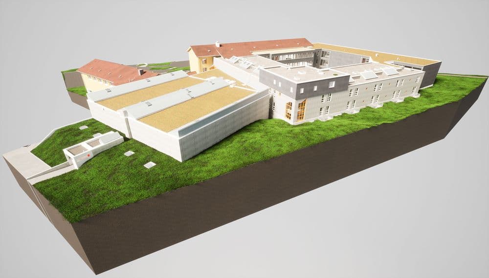 3D-Modell eines modernen Gebäudekomplexes mit grünen Bereichen auf einem geländeerhöhten Abschnitt.
