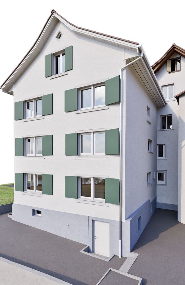 Modernisiertes Mehrfamilienhaus mit weißer Fassade, grünen Fensterläden und Satteldach, Seitenansicht mit mehreren Fenstern und Eingangstür, vor hellem Hintergrund.