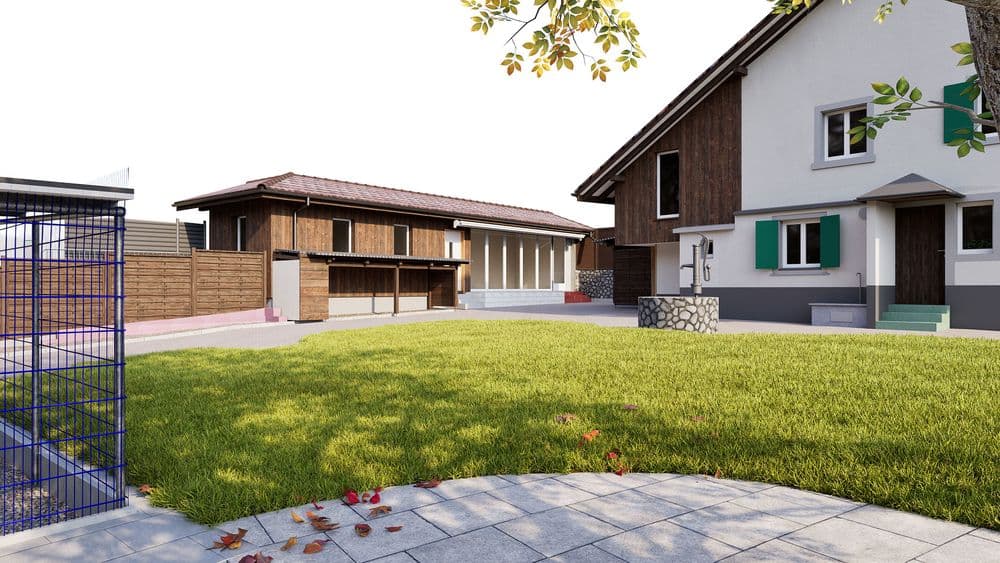 Moderner Bauernhof mit Wohnhaus und Scheune, grüner Rasenfläche im Innenhof, Pflasterweg im Vordergrund und Holzfassaden; ländliche Architektur bei Tageslicht.