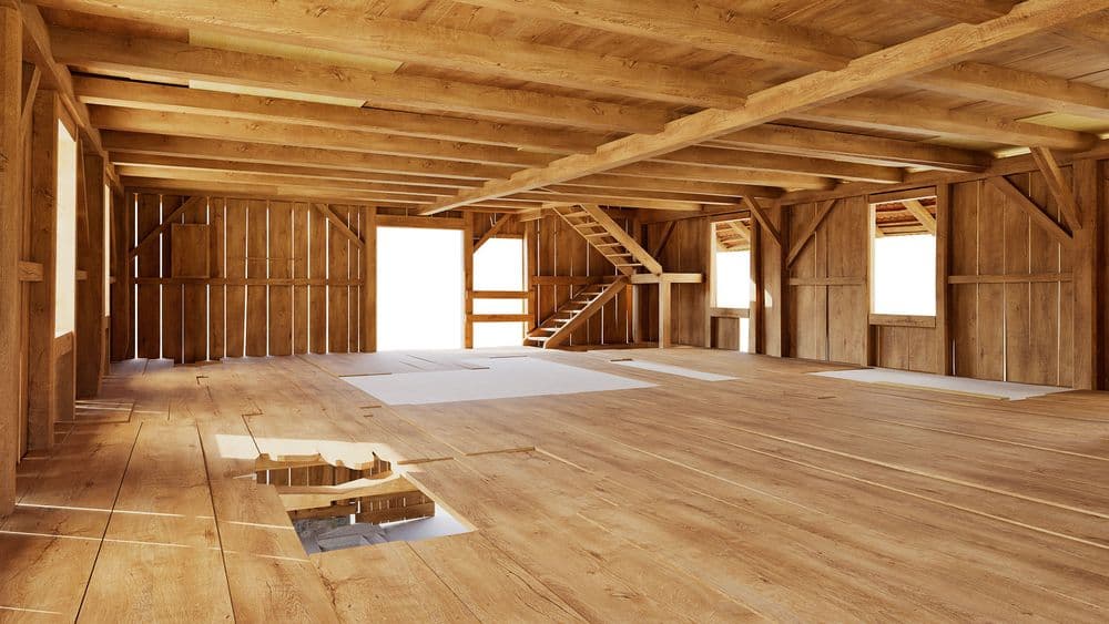 Heller Holz-Dachboden im Bauernhausstil mit sichtbaren Balken, Holzdielen, Treppe zur Galerie und mehreren Fenstern; leerer Innenraum, rustikal und geräumig.